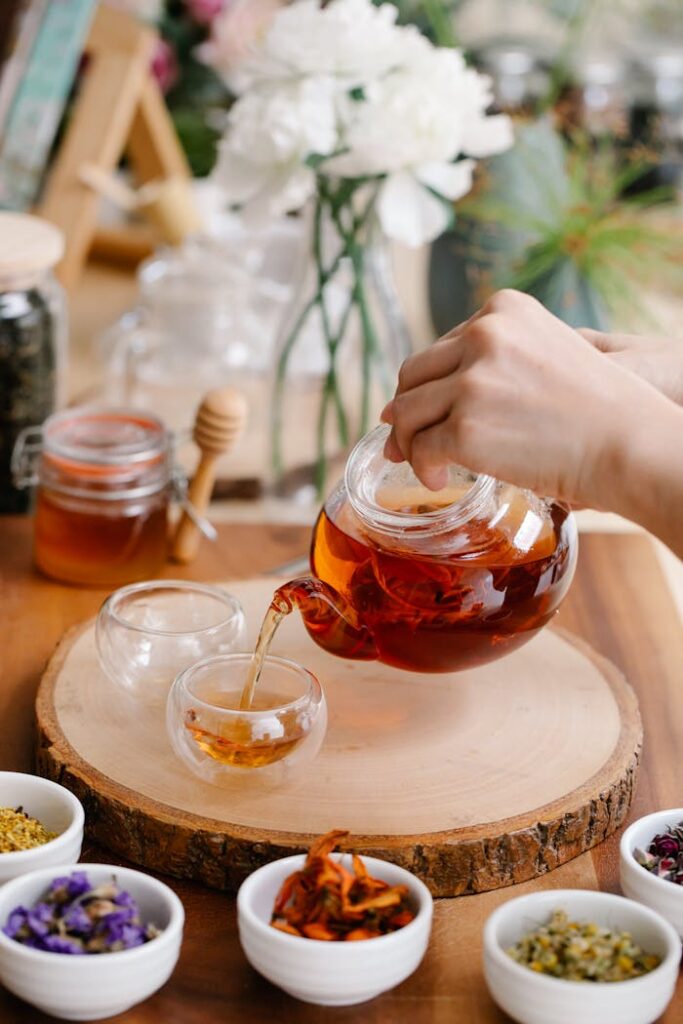 Woman Brewing Herb Tea and White Flowers on Table